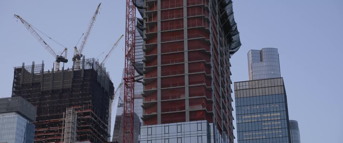 Construction in an urban environment with other skyscrapers surrounding it