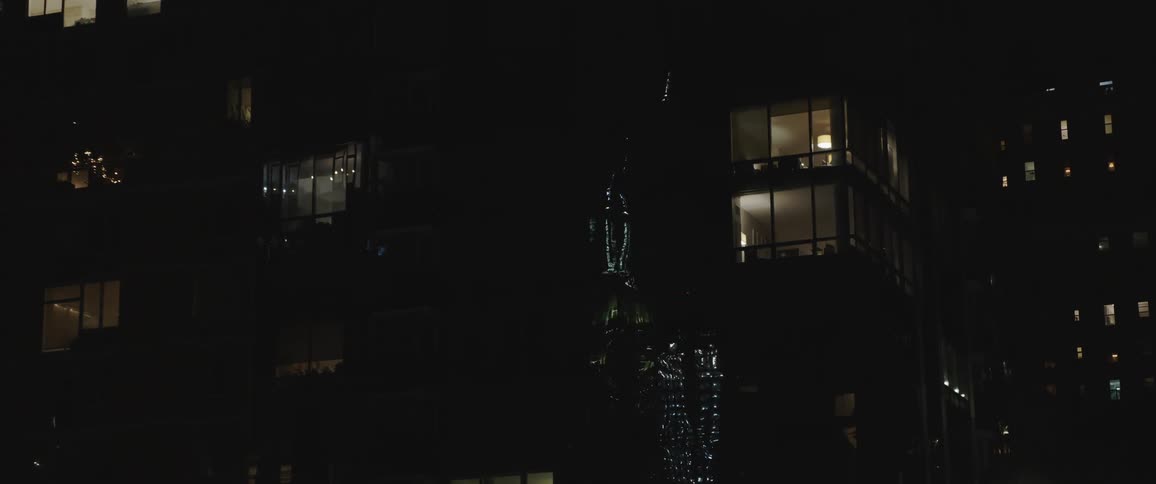 Buildings in a city at night reflecting street lights on them