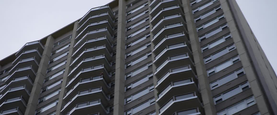 Buildings in a city with balconies and windows against a gray sky