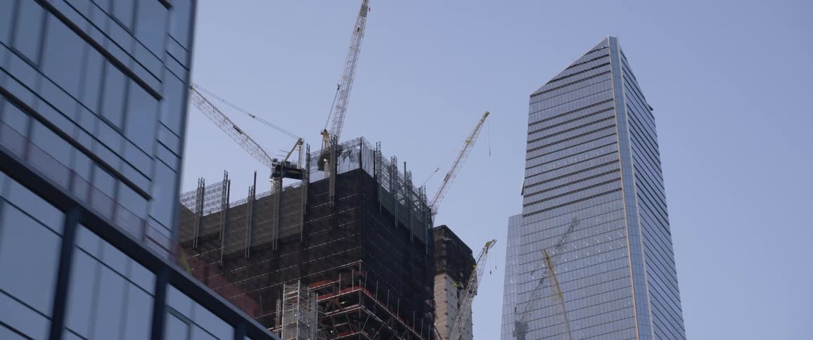 A wide shot of the tops of skyscrapers with one under construction