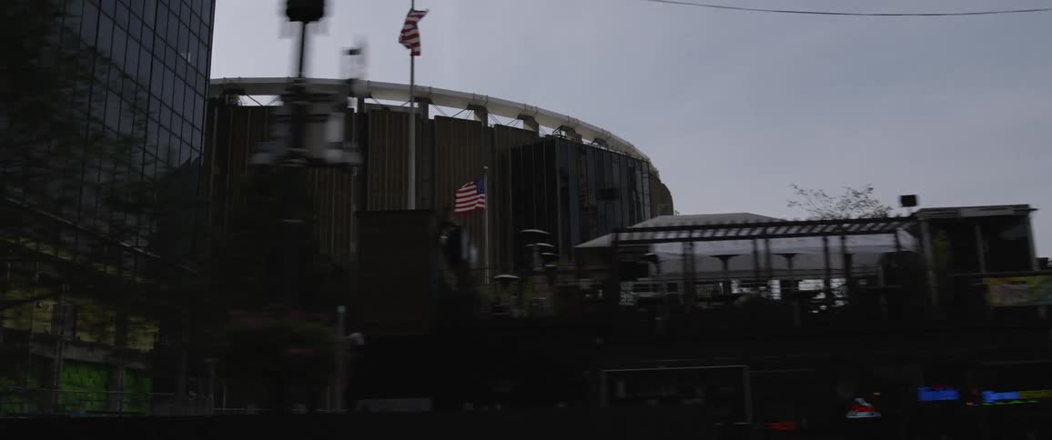 Stadium in the downtown of a city while passing by on the street in a car