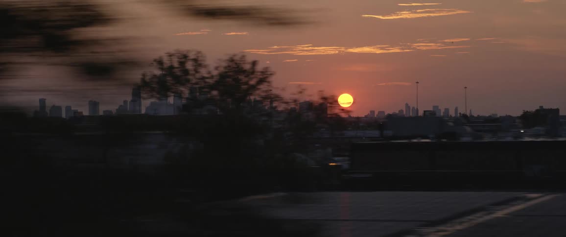New york city skyline filmed from a car on the highway at sunset