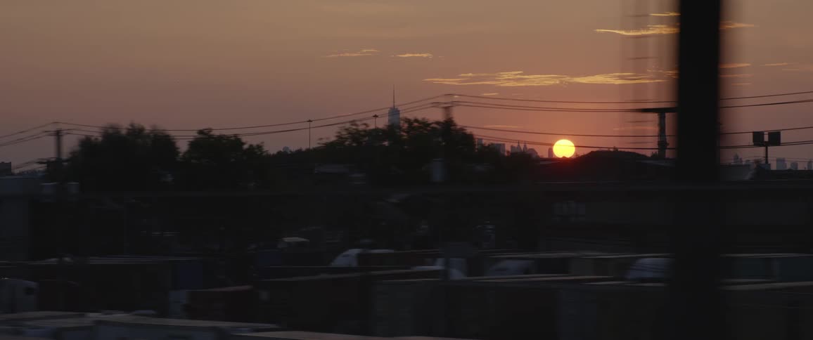 Skyline of city with the sun setting and neighborhoods surrounding the area