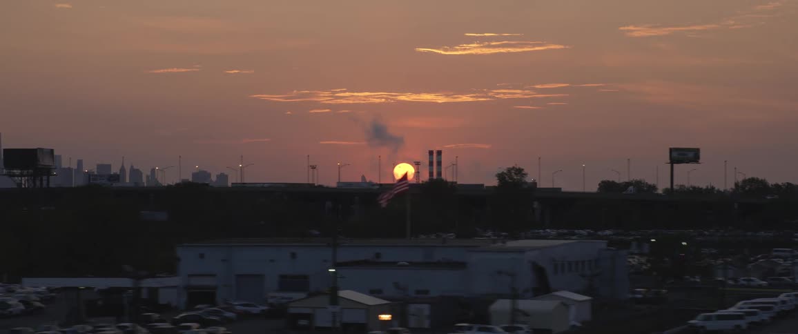 Sun on the horizon near a metro area