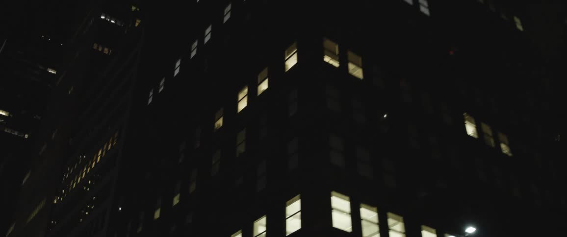 Tight shot of a dense urban area at night time with office buildings and skyscrapers