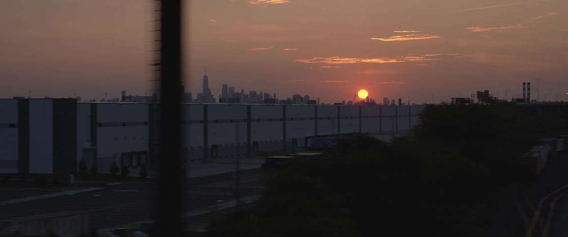 Sun setting over the new york city skyline at sunset