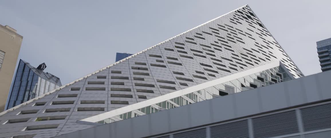 A large pyramid shaped building a metropolis on a sunny day