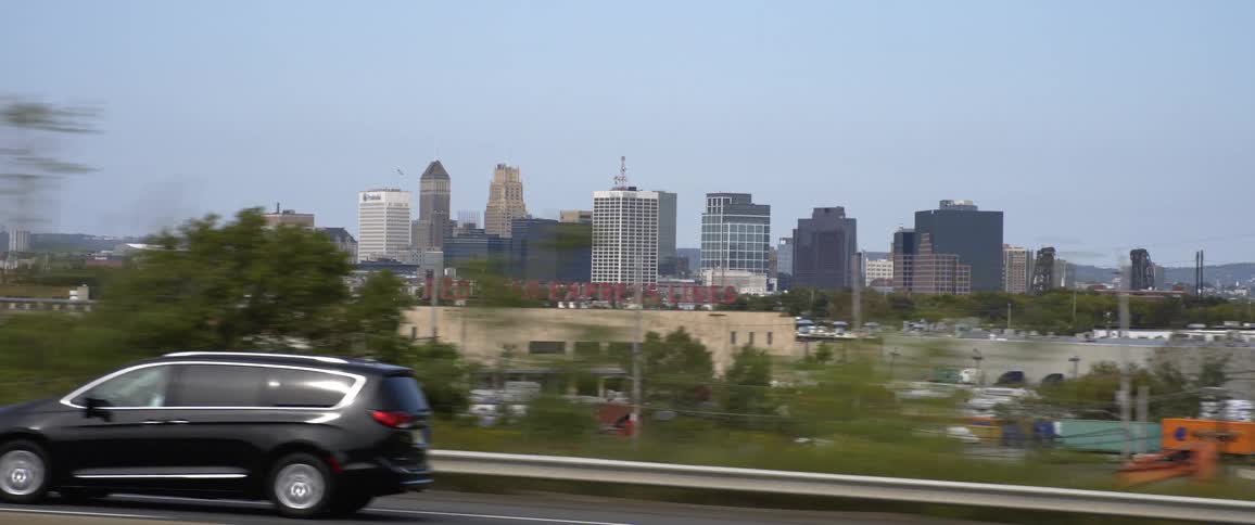 A vehicle drives on the highway beside the city