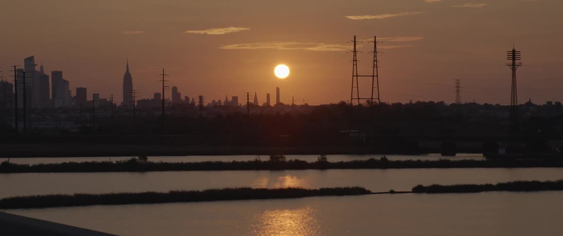 Sun reflecting over the river over the city skyline at sunset