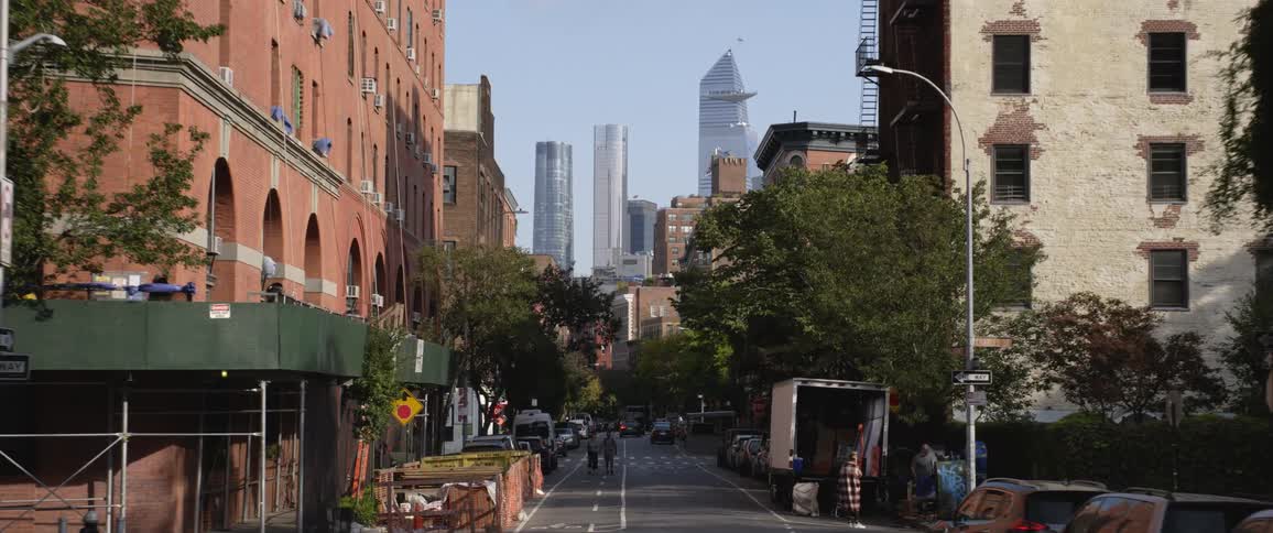 A city street lines with cars trucks trees and construction awnings