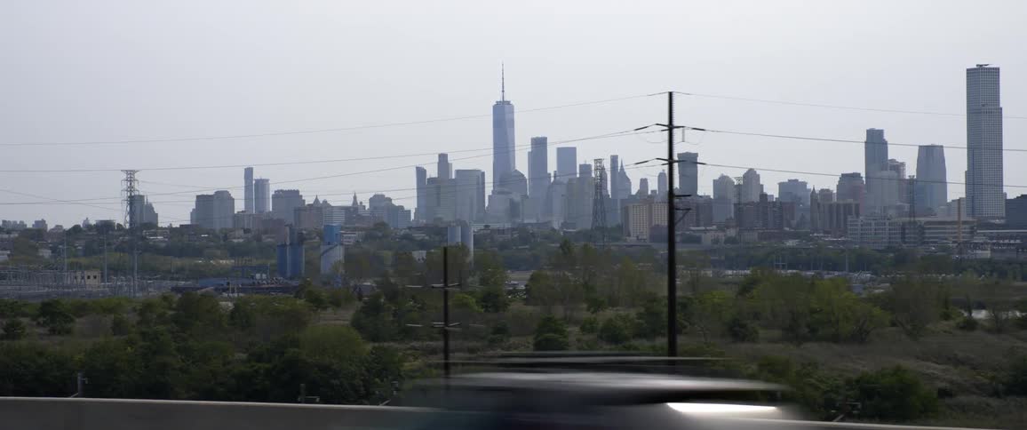Vehicles driving past a city skyline
