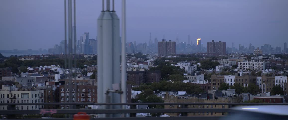 Distant big city skyline seen from a car driving across the bridge