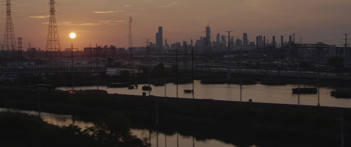 Sun reflection over the river near the new york city skyline at sunset