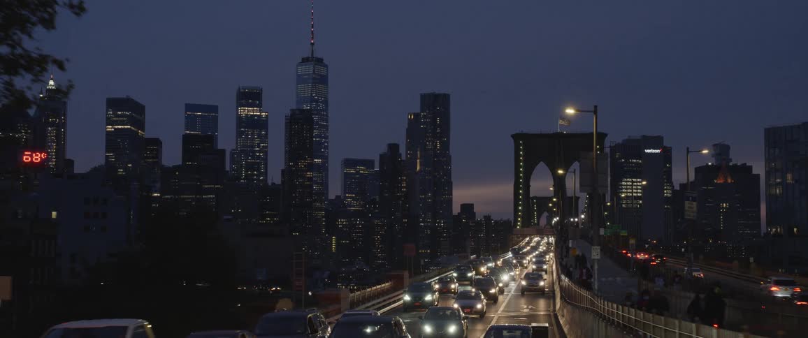 Car and people crossing a bridge in a city