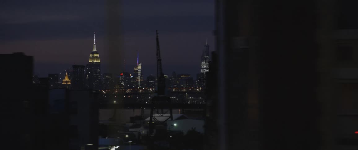 A city skyline is filled with numerous illuminated buildings