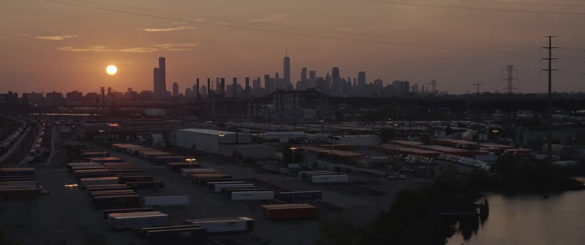 Sun reflecting over the river near the new york city skyline at sunset