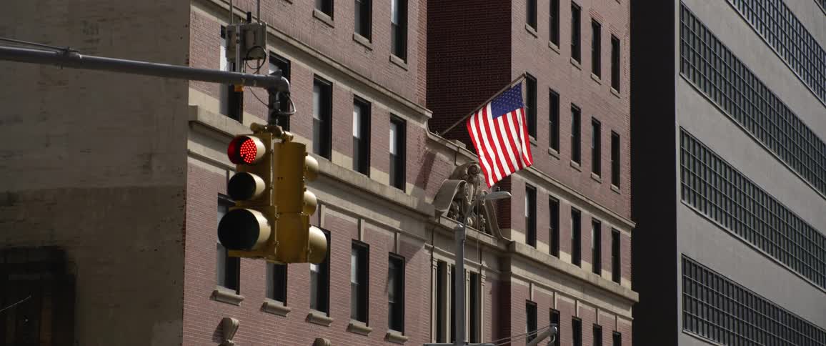 A flag hanging on the outside of an office building