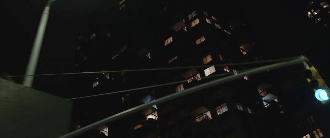 A building in the city at night with windows and interior lights shining