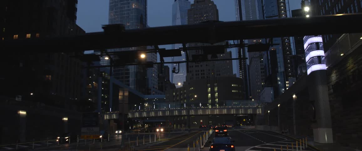 Cars driving in to a downtown area with high rise office buildings