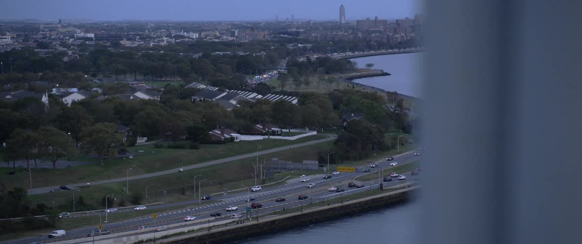 Traffic travels along a freeway on the coast on the outskirts of a metropolis