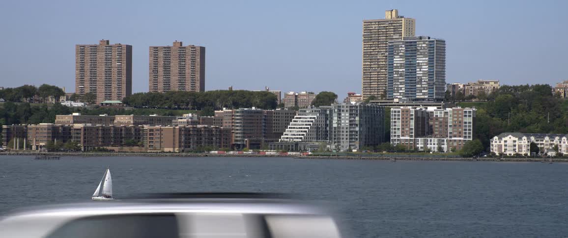 A sail boat sailing in front of a city skyline