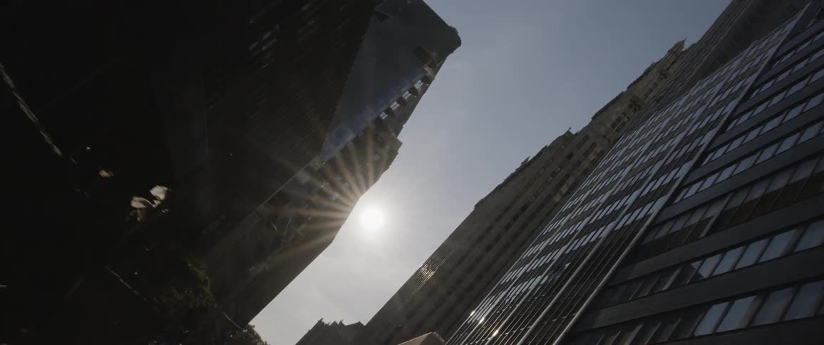 A car driving down a city street with office buildings