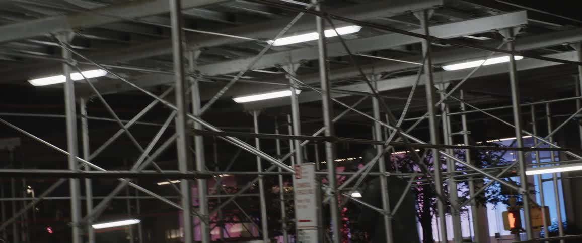 Scaffolding structure under an overpass in the city at night