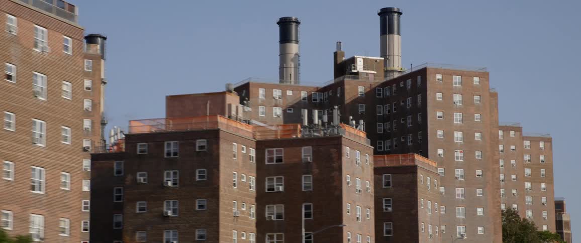 Apartment buildings in front of the chimneys of a power plant in the city at day time