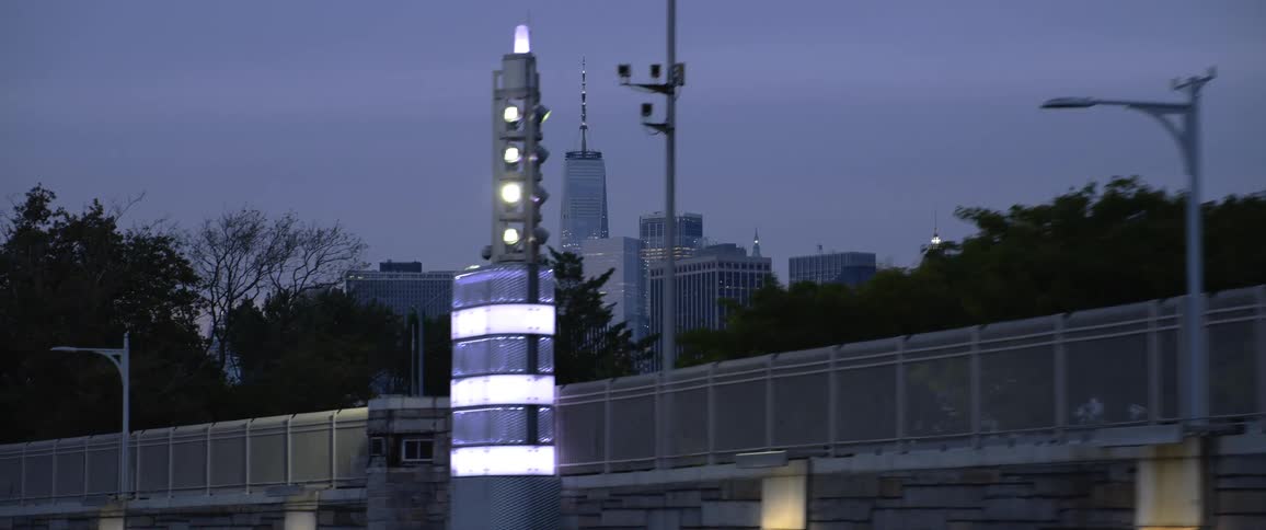 Skyline of city from a road with stone wall and metal fence