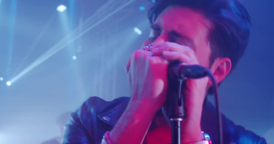 Lead singer of a rock band singing on the microphone on a concert