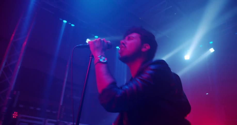 Rock band performing a show on stage lightning at night