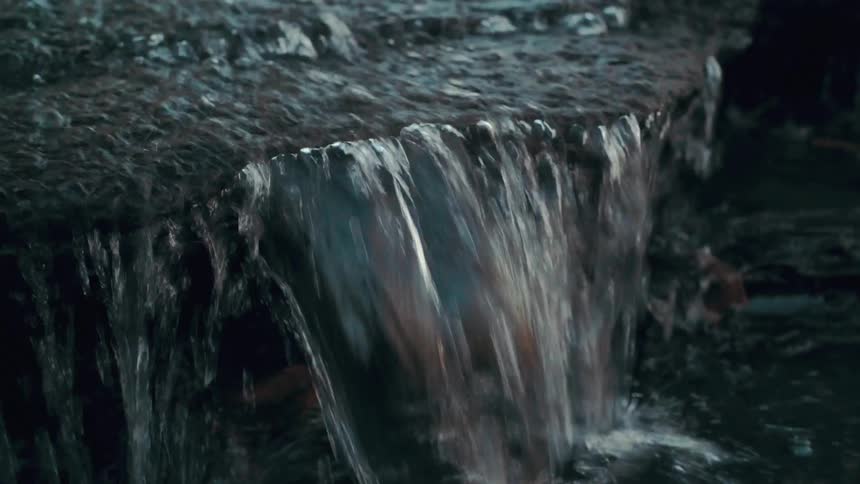 A stream of water flowing over rocks in nature