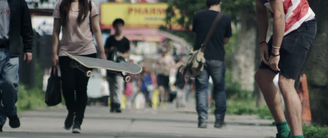 A skateboard flips in front of a person