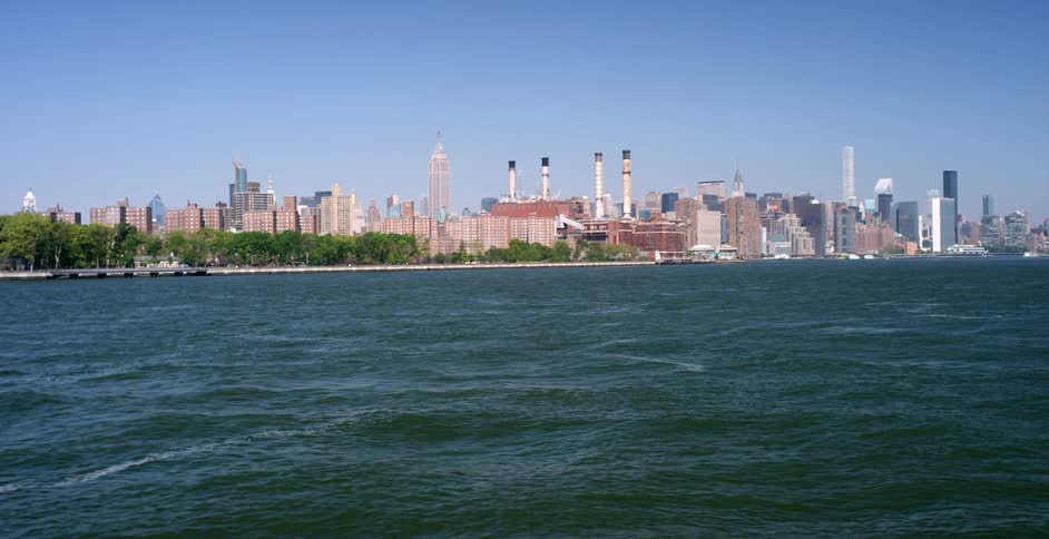 City skyscrapers and factories sit on the water's edge