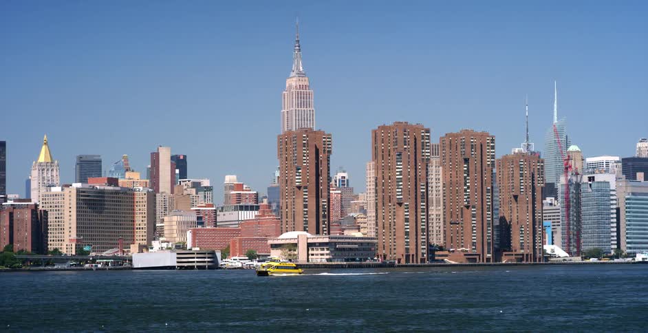 A boat goes past a waterside city