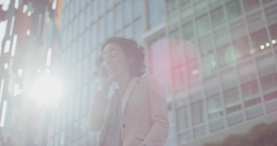 Young woman talking on the phone near a building in the citys downtown