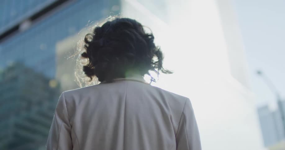 A woman is standing in front of a tall building