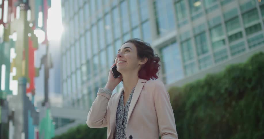 A woman talks on her cell phone outside an office building