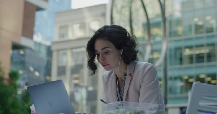 Woman working on a laptop in a table on the citys downtown