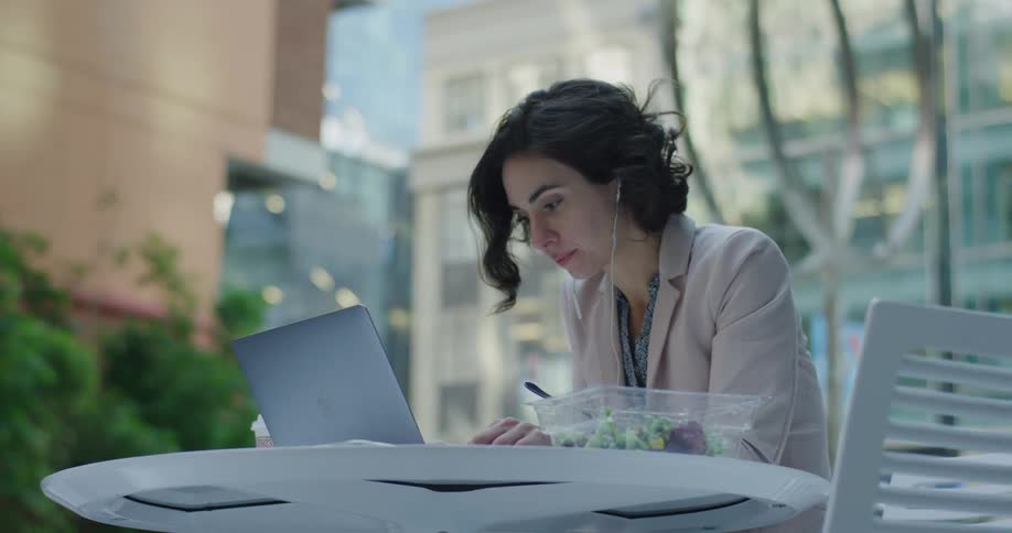 Woman working on a laptop in a restaurant table on the citys downtown