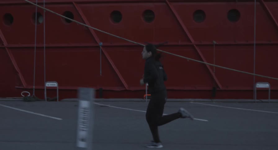 A woman jogs through a parking lot