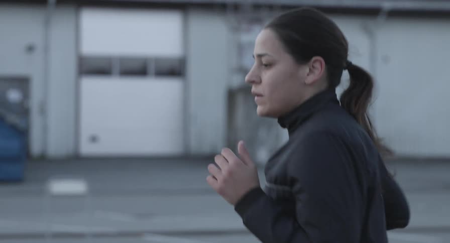A woman jogging near an industrial area