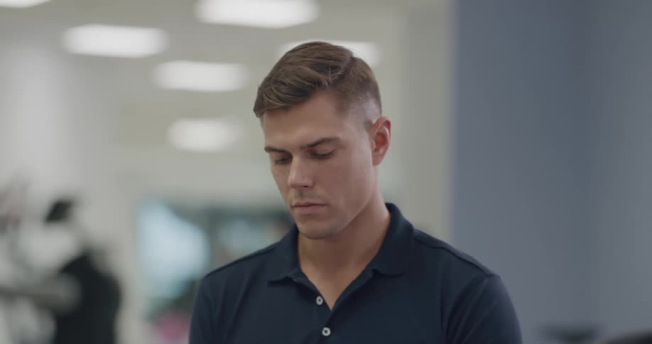 People exercise on machines as a man puts on gloves before working on a patient