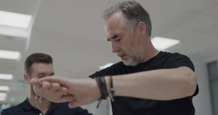 A physical therapist helps a man with balancing