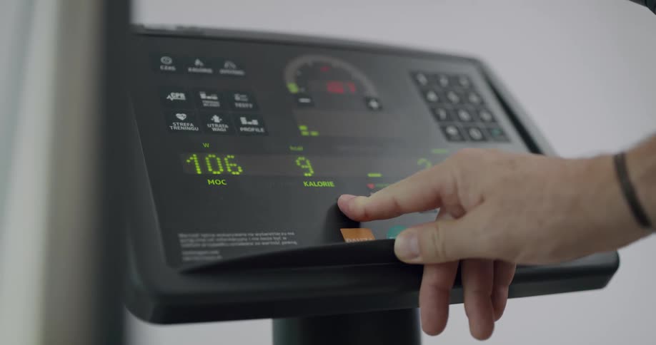 A man adjusts time and speed on the monitor for fitness equipment