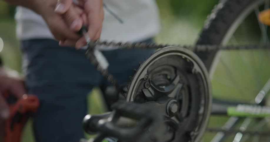 Two people fix a bicycle together with a screwdriver