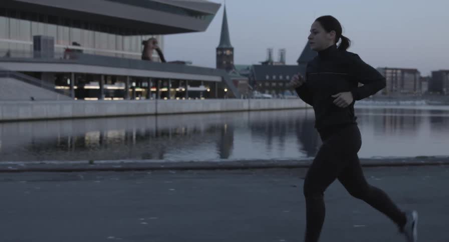 A woman is jogging on a pier