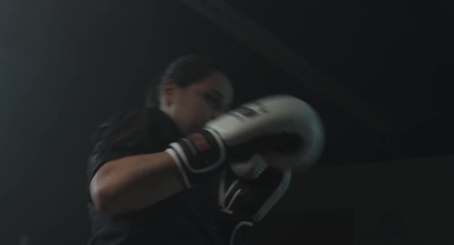 A man and woman spar with boxing gloves