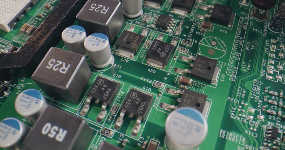 A green printed circuit board has multiple components attached to it