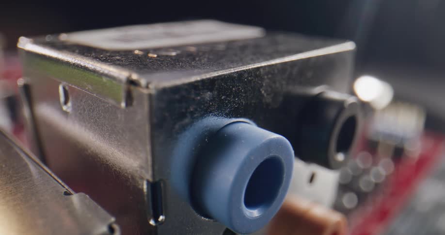 Close up of a metal housing unit with a blue and black circular rubber pieces with engraving on the metal